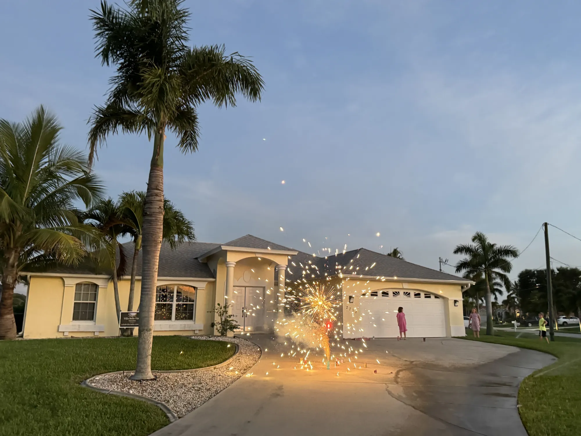 Villa Bella Vista at dusk with royal palms and double garage